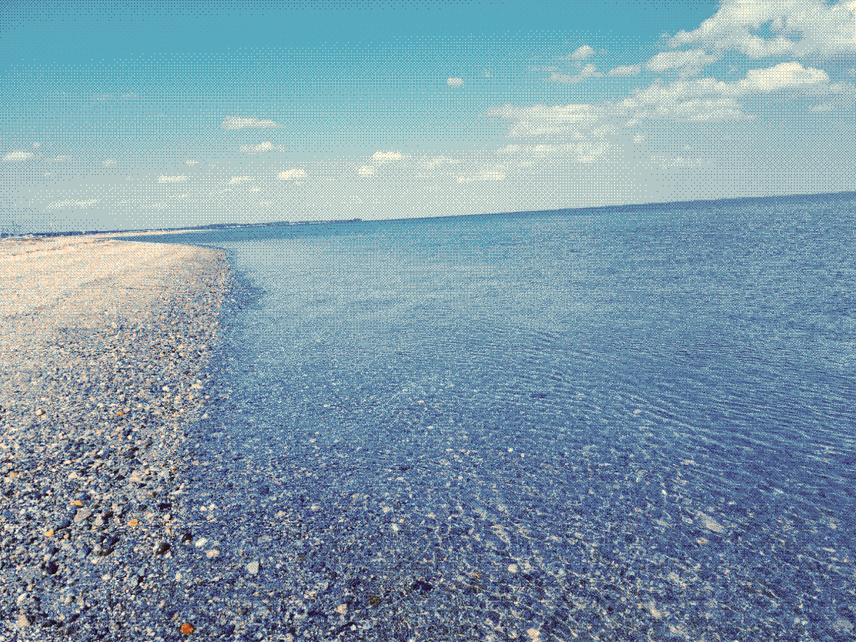 A photograph of a calm ocean shoreline.