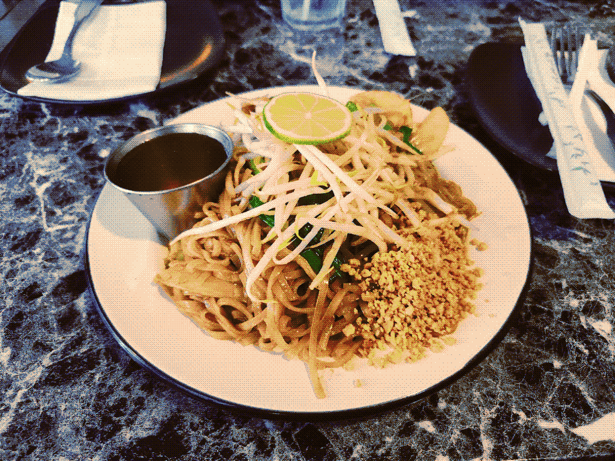 A photograph of pad thai, beautifully plated with lots of bean sprouts and peanuts.